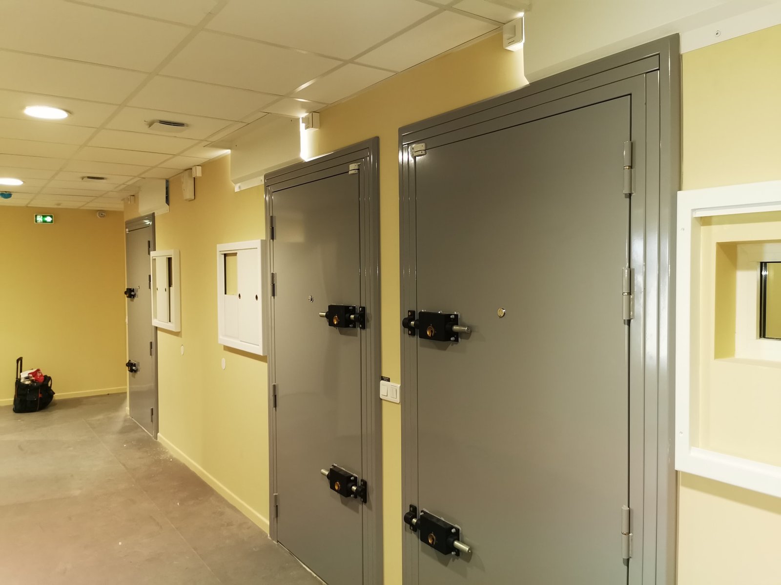 Couloir des cellules de garde à vue avec portes blindées